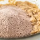 Mixing ingredients in a glass mixing bowl to bake chocolate graham crackers.