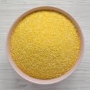 Organic Masarepa corn meal in a pink bowl over white wooden background, top view. Overhead, from above. Closeup.